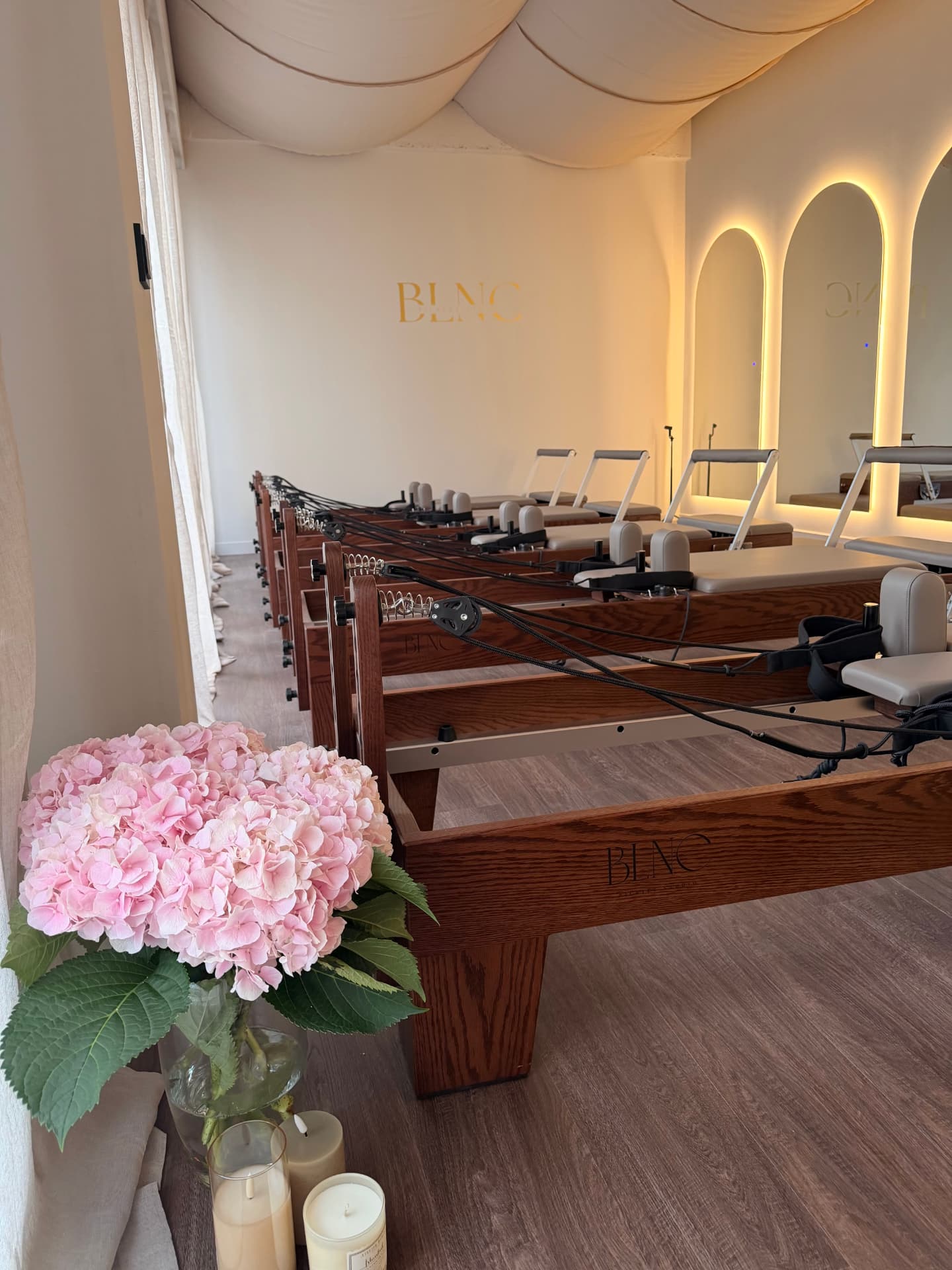 Roze hortensia naast een houten reformer met BLNC-logo