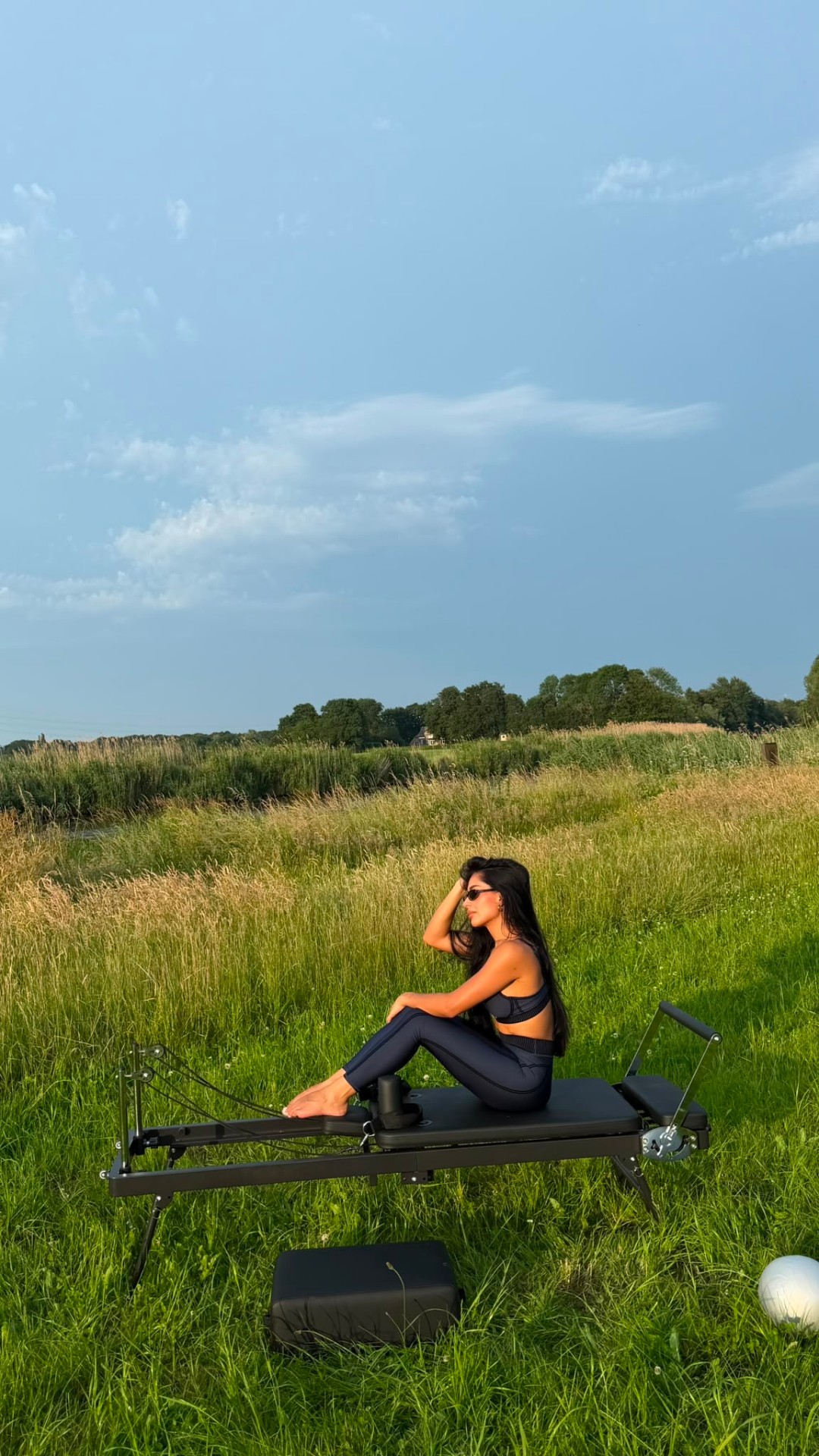 Reformer pilates in de natuur — zijaanzicht